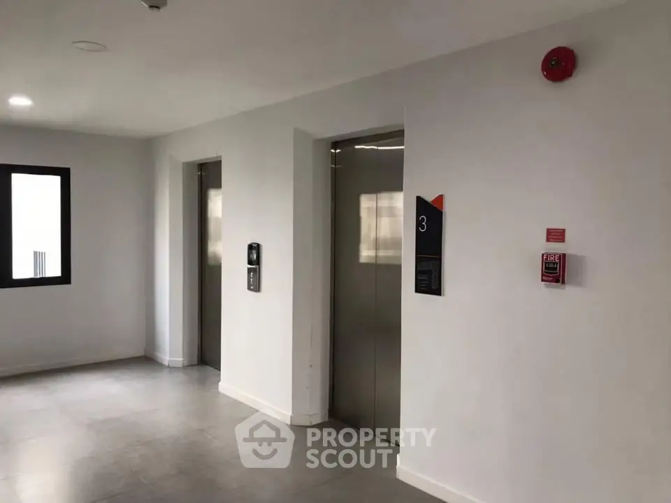 Modern building elevator lobby with sleek design and fire safety features.