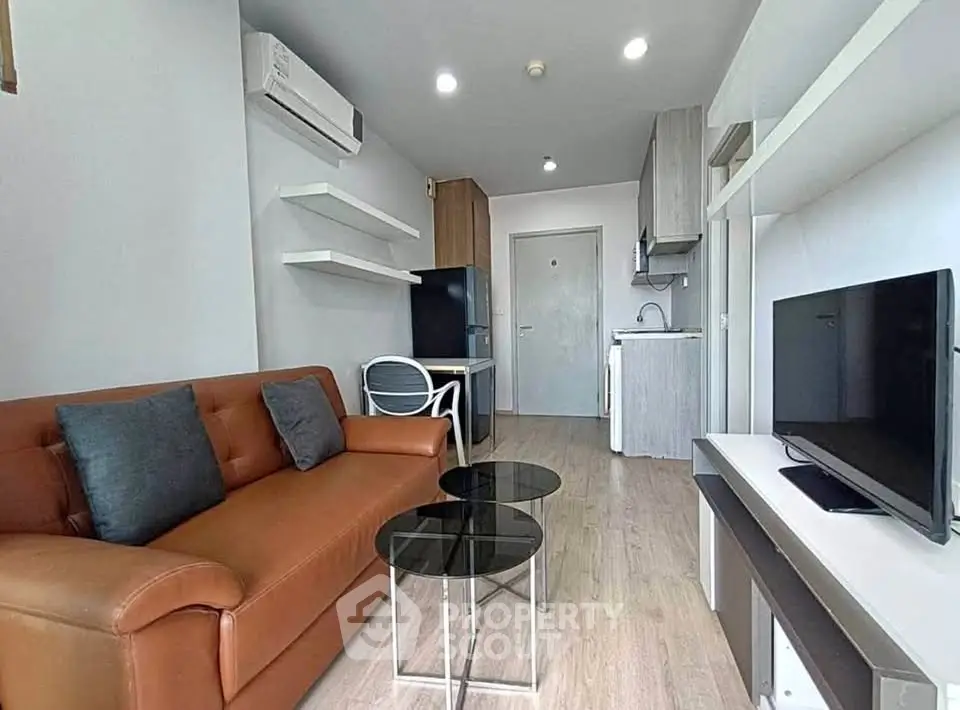 Modern living room with stylish furniture and open kitchen layout in a cozy apartment.