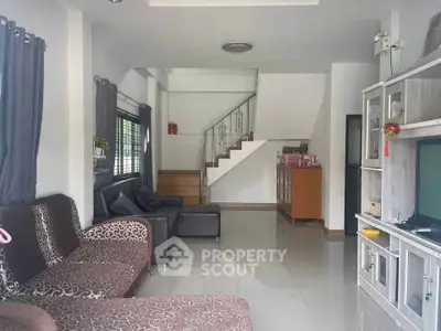 Spacious living room with modern decor and sleek staircase in a stylish home.