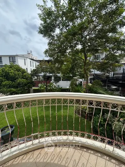 Charming balcony view overlooking lush garden in modern residential area.