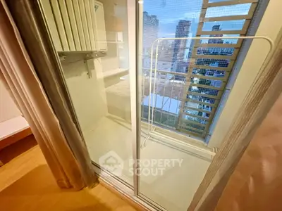 Modern apartment balcony with city view and sliding glass doors, perfect for urban living.