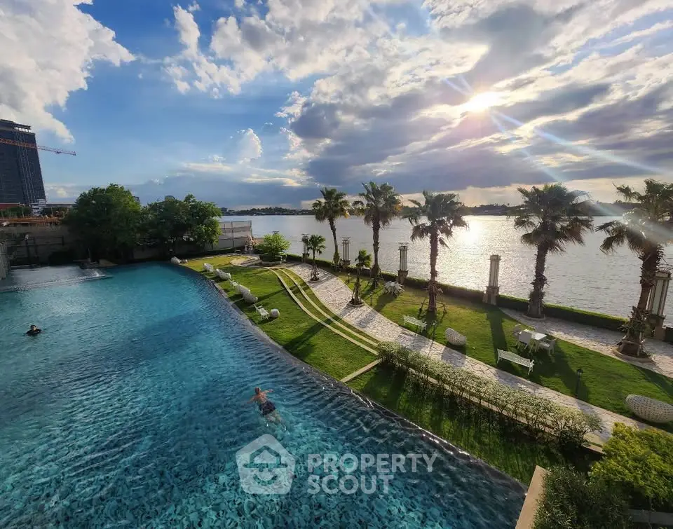 Luxurious waterfront pool with stunning sunset view and lush palm trees