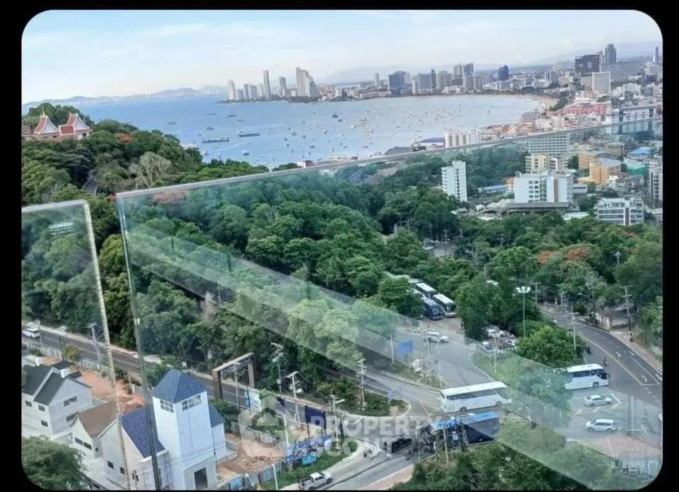Stunning panoramic view of city skyline and ocean from high-rise balcony, perfect for urban living.