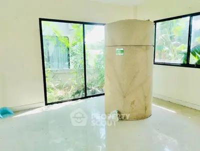 Spacious room with large windows and unique cylindrical feature