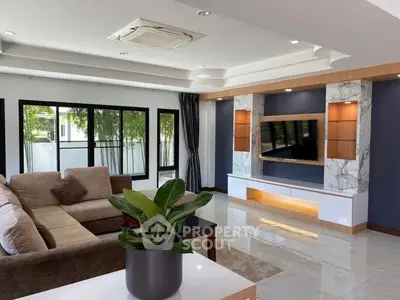 Luxurious living room with modern decor, large windows, and stylish entertainment center.