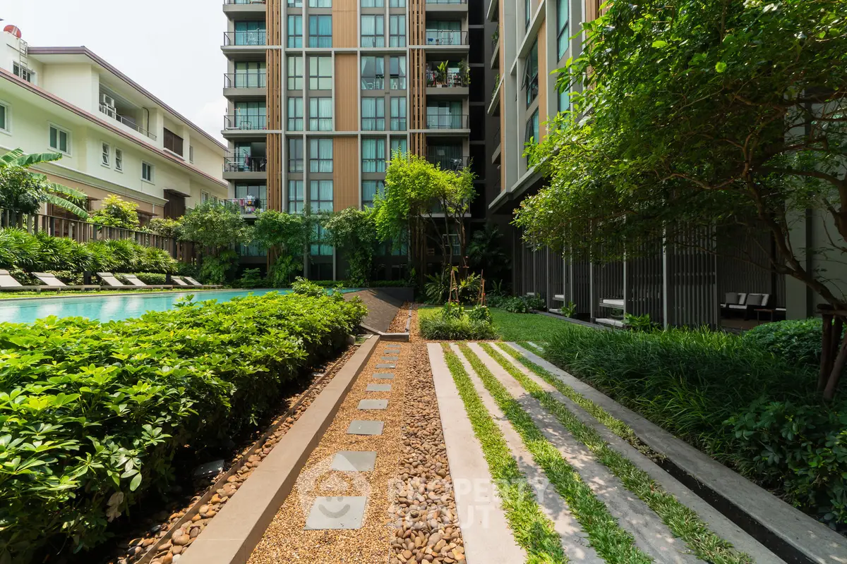 Luxurious apartment complex with lush garden and inviting pool area