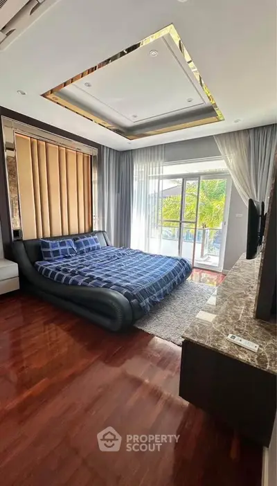 Luxurious bedroom with modern decor and large windows opening to a scenic balcony view.