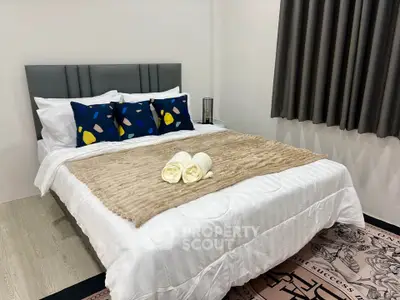 Cozy bedroom with stylish decor and plush bedding in modern apartment.
