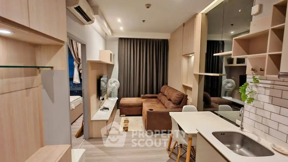 Modern living room with open kitchen and cozy brown sofa in stylish apartment