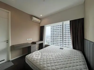 Modern bedroom with large window offering stunning city views in a high-rise apartment.