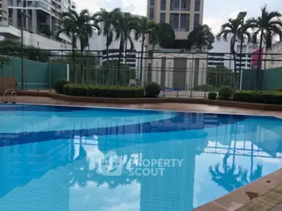 Luxurious residential pool area with lush greenery and modern architecture.