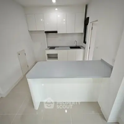 Modern minimalist kitchen with sleek white cabinets and island