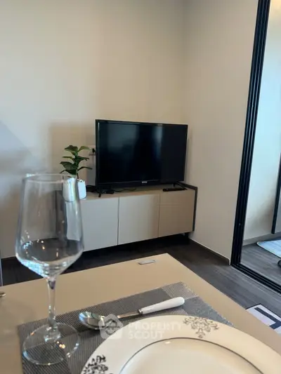 Modern living room with sleek TV setup and elegant dining area, perfect for contemporary urban living.