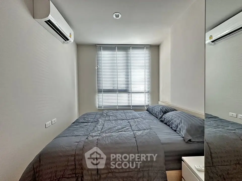 Cozy bedroom with modern air conditioning and natural light through blinds.