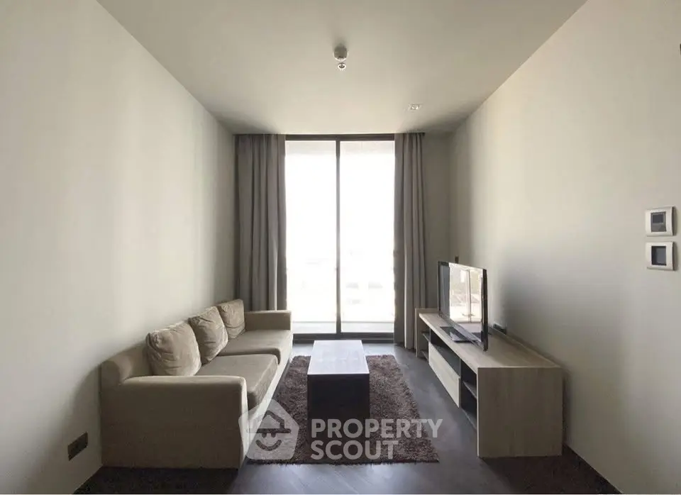 Modern minimalist living room with cozy sofa and large window view.