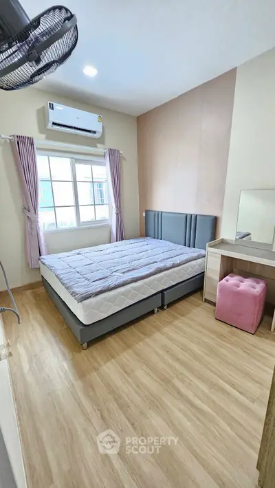 Cozy bedroom with modern decor, featuring a comfortable bed, stylish vanity, and ample natural light.