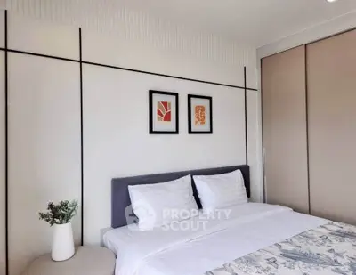 Modern bedroom with stylish decor and cozy bedding in a contemporary apartment.