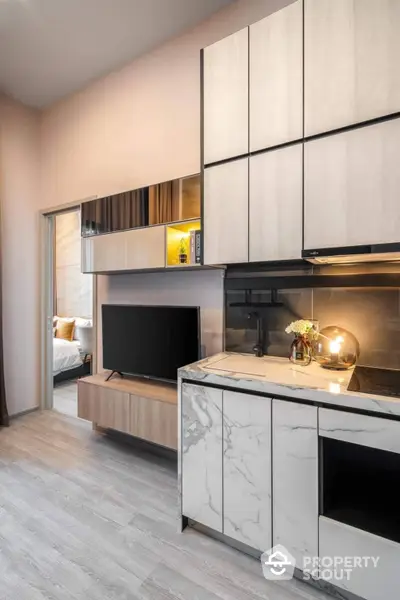 Modern studio apartment with seamless living room and bedroom design, featuring elegant marble accents and sleek built-in cabinetry.