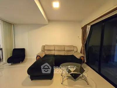 Modern living room with sleek furniture and large glass doors for natural light.