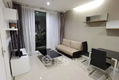 Modern living room with sleek furniture and city view through large window.