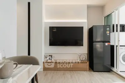 Modern living room with sleek TV setup and stylish decor in a contemporary apartment.