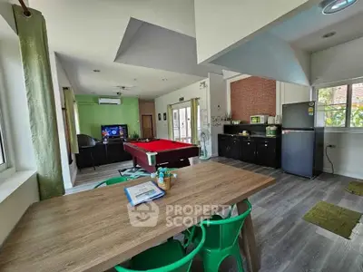 Spacious living area with pool table and modern kitchen in open layout design.