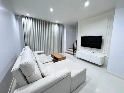 Modern living room with sleek furniture and large TV, perfect for relaxation and entertainment.
