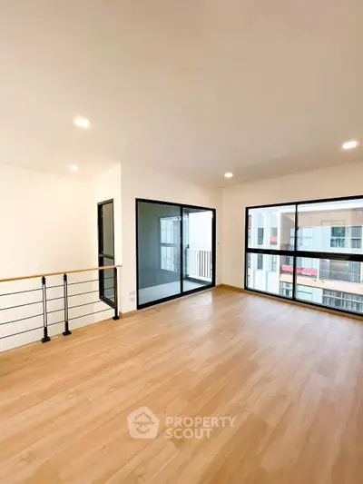 Spacious modern living room with large windows and wooden flooring