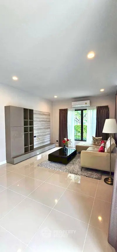Spacious modern living room with elegant decor and large window view.
