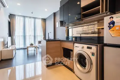 Modern open-layout kitchen with washing machine and sleek appliances in a bright apartment.