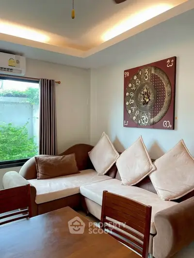 Cozy living room with stylish decor and natural light, featuring a comfortable sectional sofa and modern wall art.