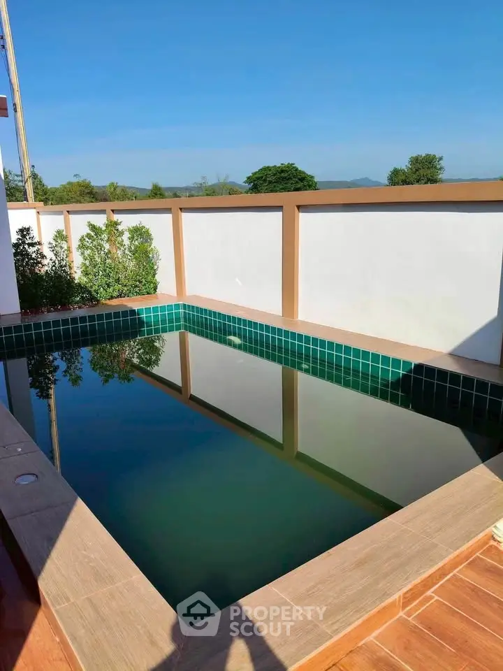 Charming private pool with serene surroundings and clear blue sky, perfect for relaxation and leisure.