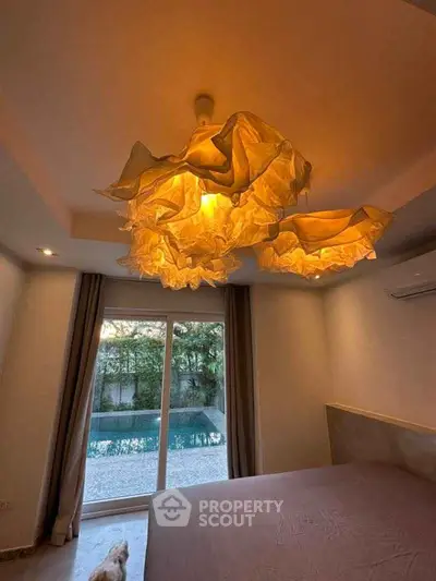 Luxurious bedroom with unique lighting and pool view, perfect for relaxation.