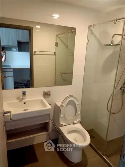 Modern bathroom with glass shower and sleek fixtures in a contemporary apartment.