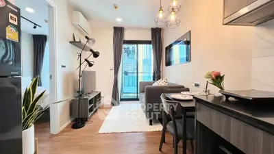 Modern living room with stylish decor and open kitchen layout in a cozy apartment.