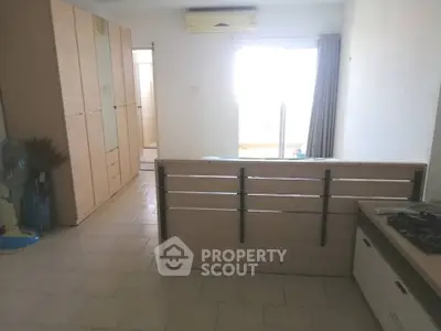 Spacious studio apartment with modern kitchen and ample storage space.
