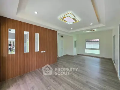 Spacious modern living room with elegant wood paneling and recessed lighting