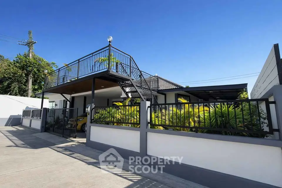 Modern two-story house with sleek balcony and lush garden