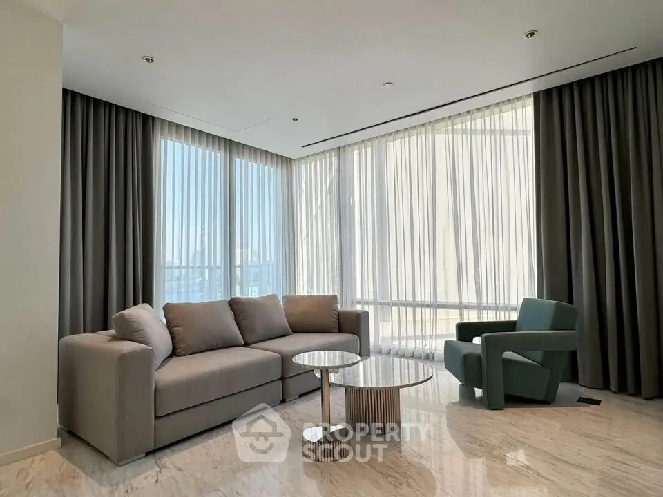 Luxurious modern living room with elegant furniture and floor-to-ceiling windows offering stunning views.