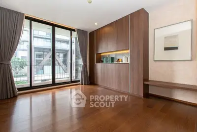 Spacious modern living room with large windows and elegant wooden flooring.