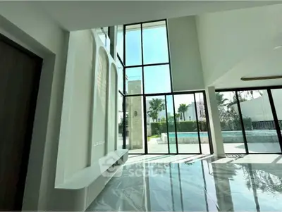 Luxurious modern living room with floor-to-ceiling windows and pool view