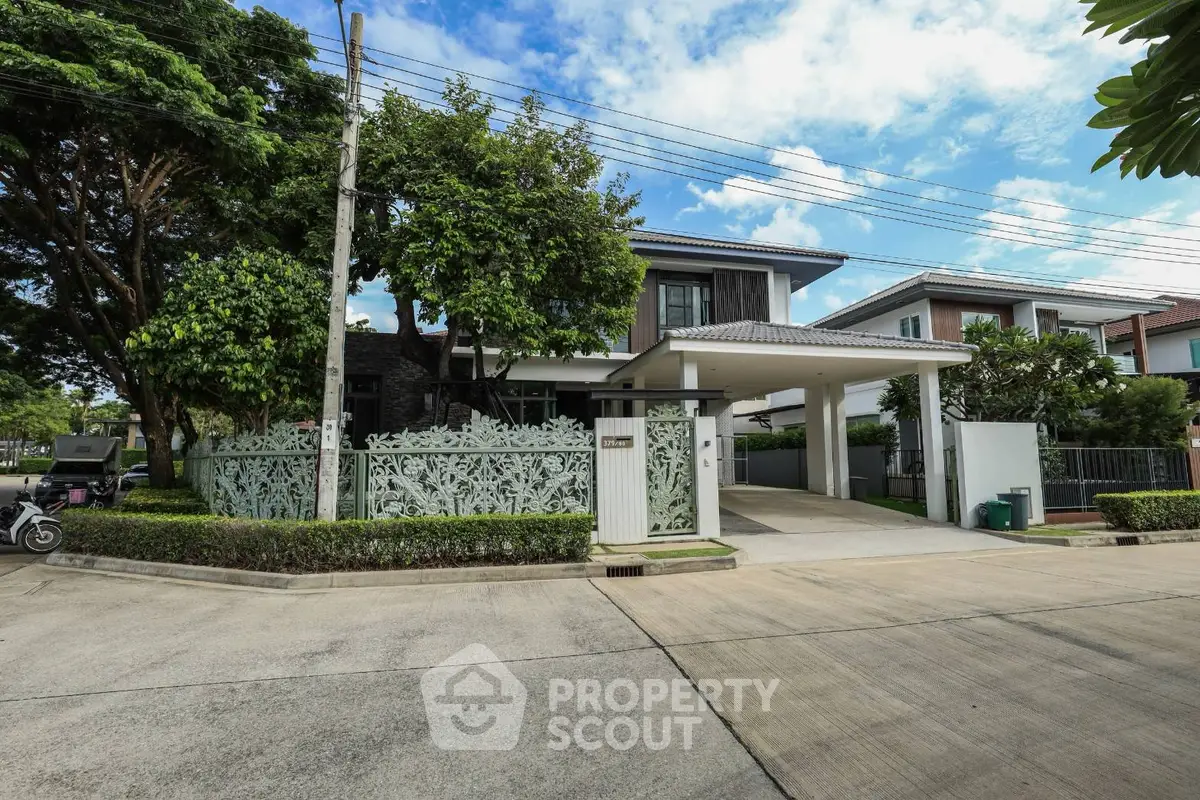 Modern two-story house with lush greenery and spacious driveway in a serene neighborhood.