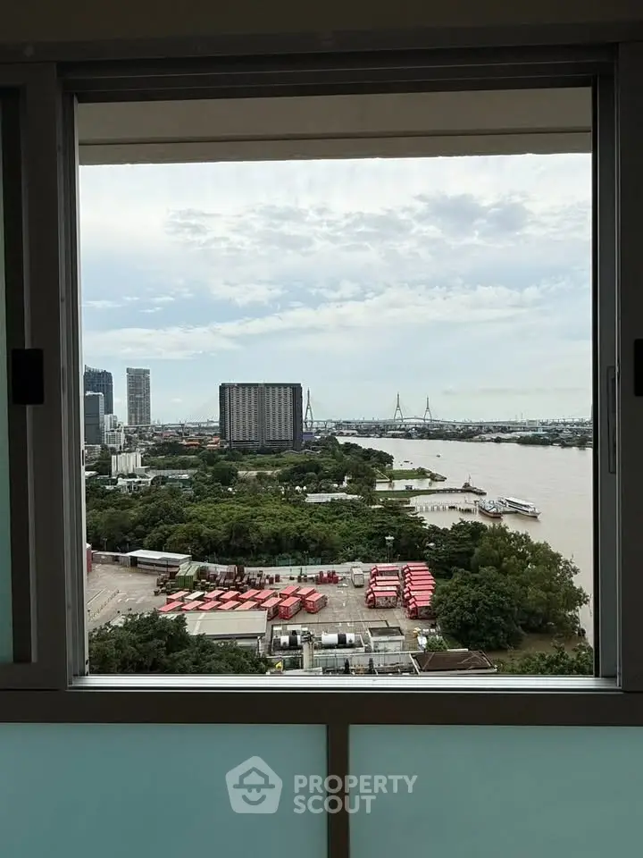 Stunning river view from high-rise window with cityscape and greenery.