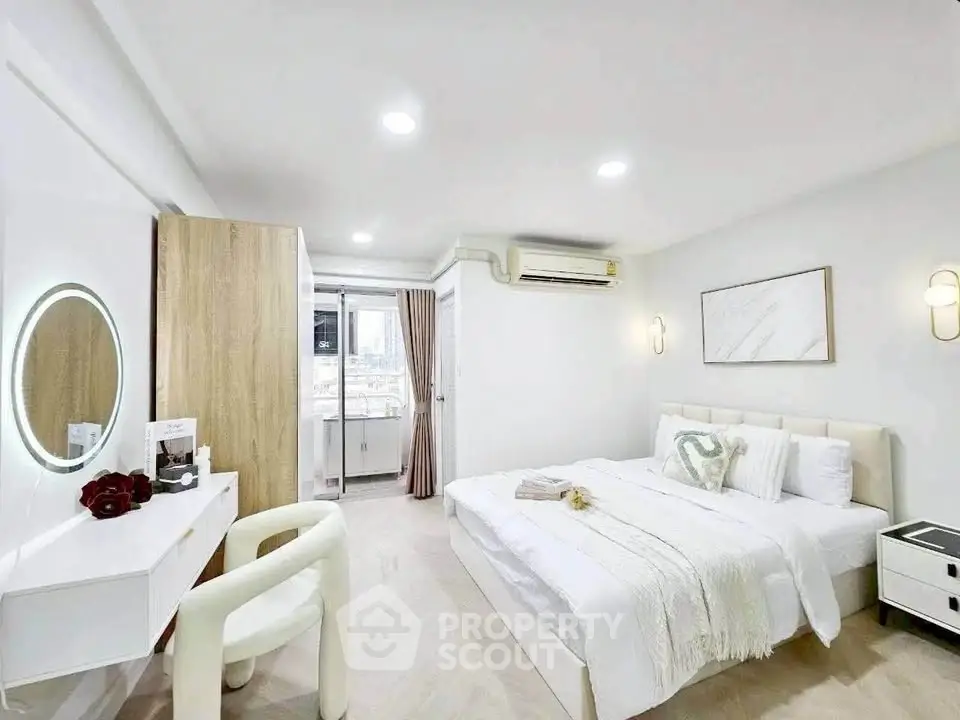 Modern bedroom with stylish decor and natural light, featuring a cozy bed and elegant furnishings.