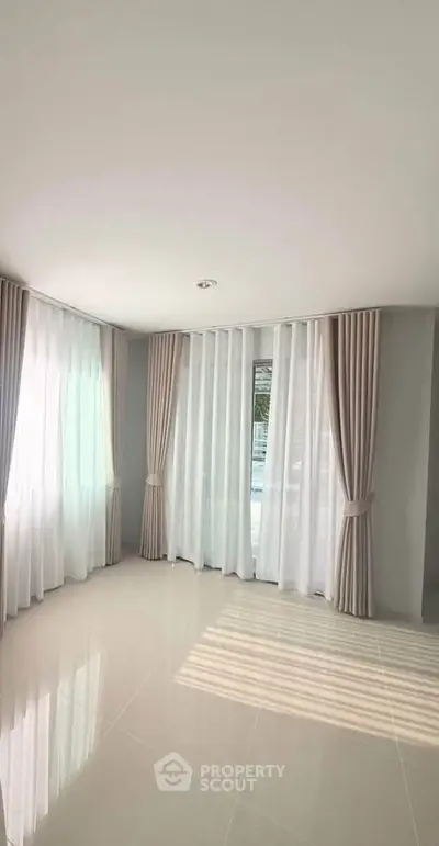 Bright and airy living room with large windows and elegant curtains, perfect for natural light lovers.