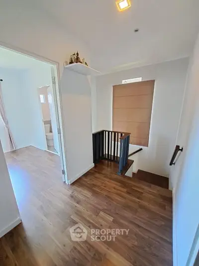 Spacious hallway with wooden flooring and modern staircase design