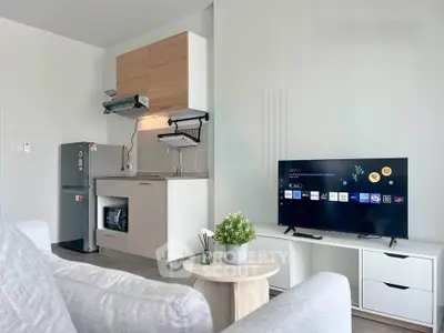 Modern living room with sleek kitchen and smart TV setup, perfect for urban living.
