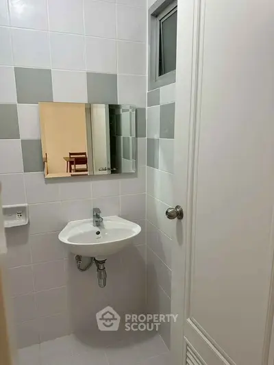 Compact bathroom with modern sink and mirror in a minimalist design.