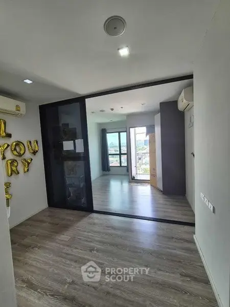 Modern apartment with spacious living area and large windows offering city views.