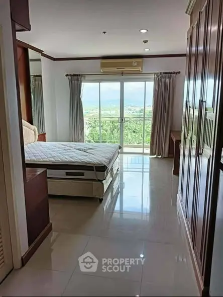 Spacious bedroom with large windows offering stunning views and ample natural light.